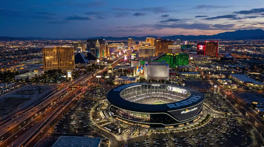 Vista aérea del skyline de Las Vegas con un estadio de fútbol americano iluminado en primer plano