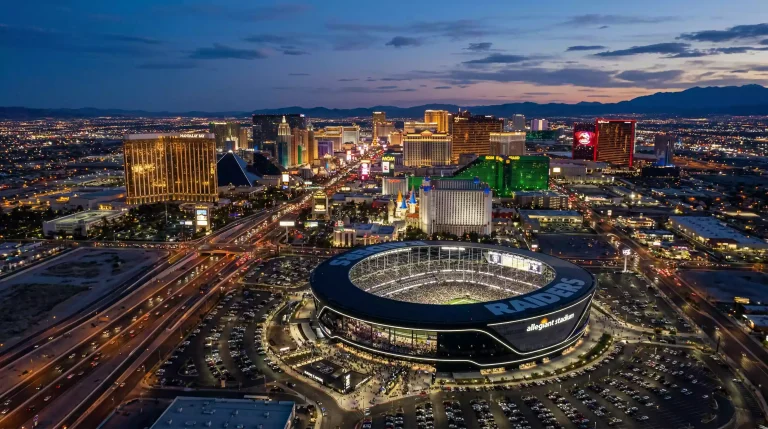 Vista aérea del skyline de Las Vegas con un estadio de fútbol americano iluminado en primer plano
